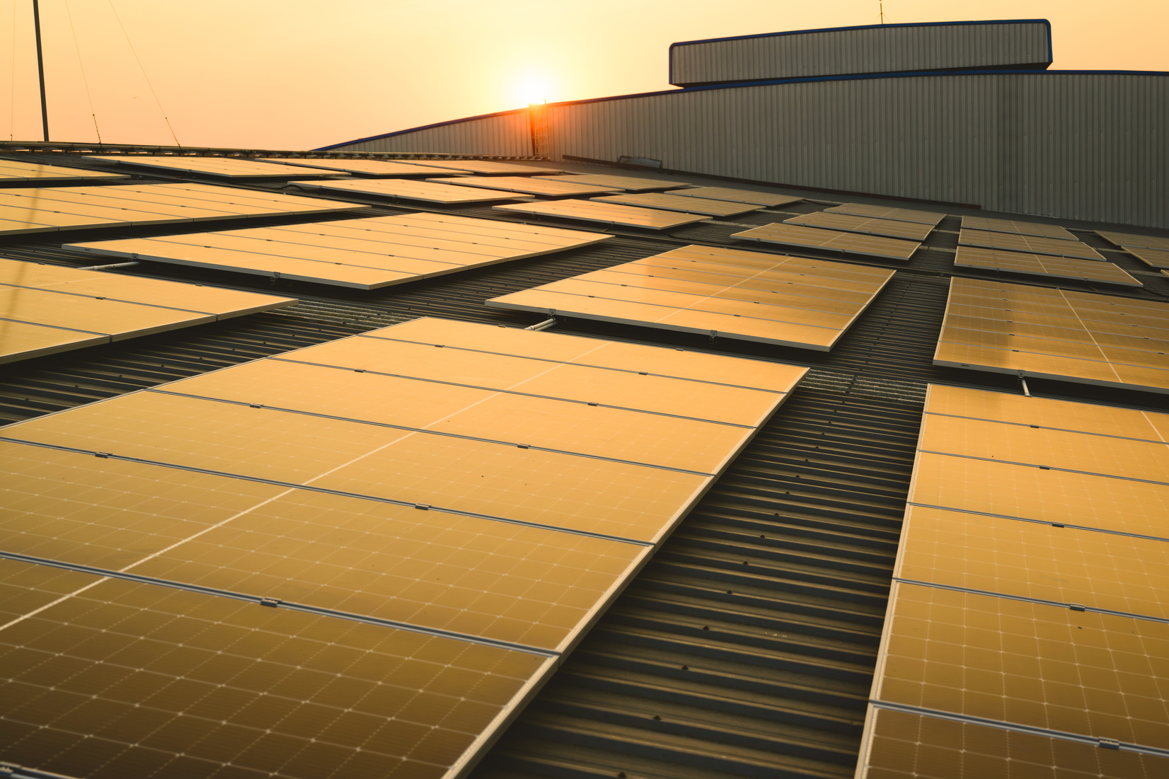 Photovoltaic solar panels on rooftop with sunset at solar cell farm